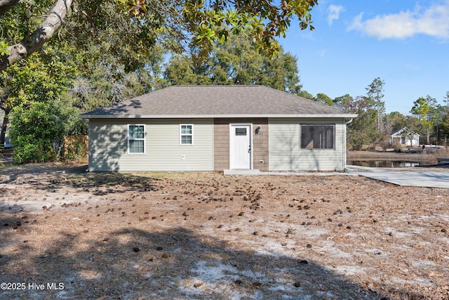 rear view of property with a shingled roof