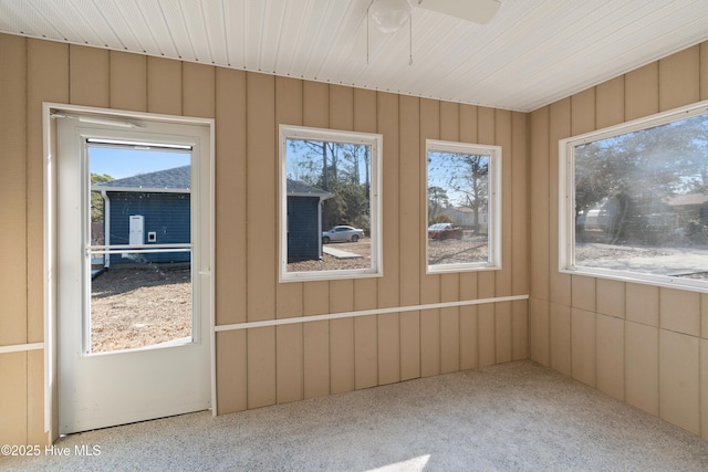 unfurnished sunroom featuring ceiling fan