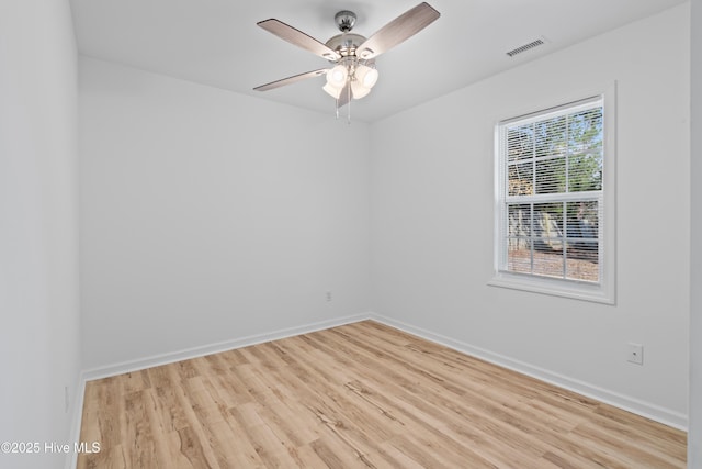 spare room with light wood finished floors, a ceiling fan, visible vents, and baseboards