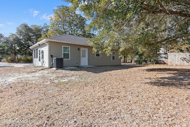 view of front of property featuring a shingled roof, central AC, and fence