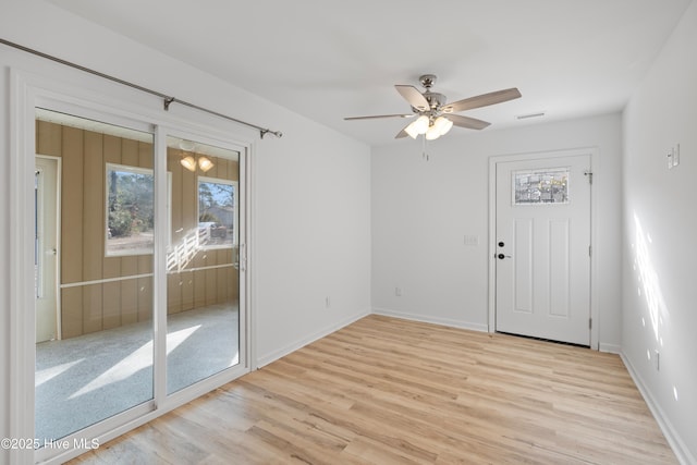 unfurnished room featuring visible vents, light wood finished floors, a ceiling fan, and baseboards