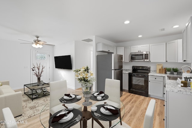 kitchen with recessed lighting, a sink, visible vents, light wood-style floors, and appliances with stainless steel finishes