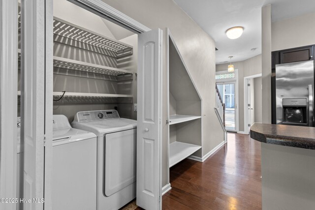 laundry area with laundry area, dark wood-type flooring, separate washer and dryer, and baseboards