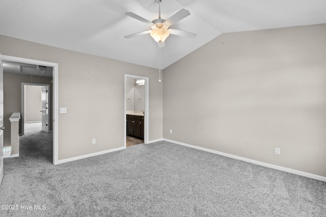 unfurnished bedroom featuring lofted ceiling, carpet, attic access, and baseboards