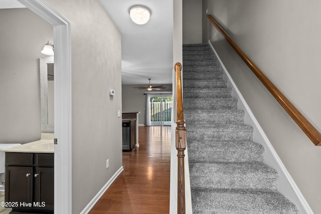 stairway with baseboards and wood finished floors