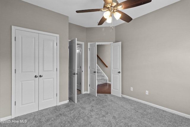 unfurnished bedroom featuring carpet, a closet, ceiling fan, and baseboards