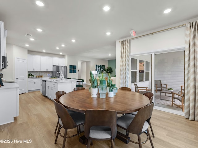 dining room featuring visible vents, light wood-style flooring, and recessed lighting