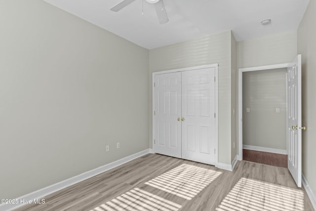 unfurnished bedroom with a closet, baseboards, and wood finished floors