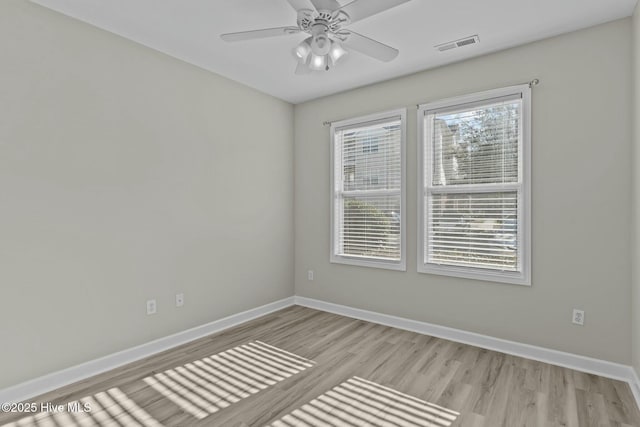 empty room with light wood-type flooring, visible vents, baseboards, and a ceiling fan