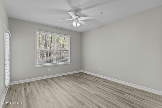 empty room featuring baseboards, ceiling fan, and light wood finished floors