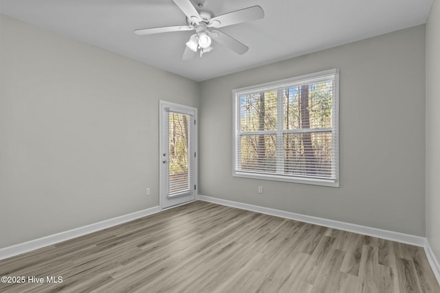 spare room with ceiling fan, light wood-style flooring, and baseboards