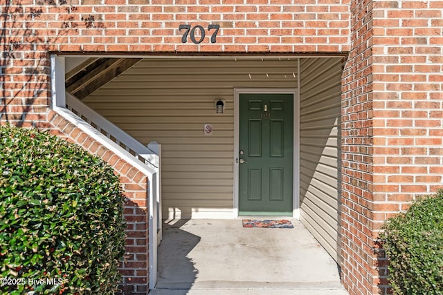 view of exterior entry featuring brick siding