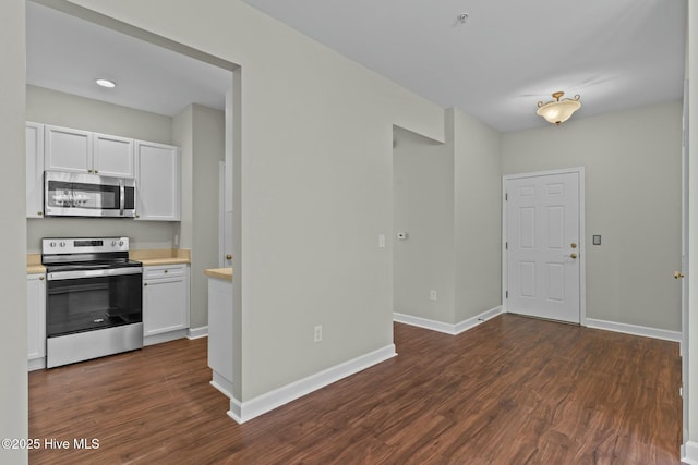 kitchen featuring white cabinets, dark wood-style floors, appliances with stainless steel finishes, and light countertops