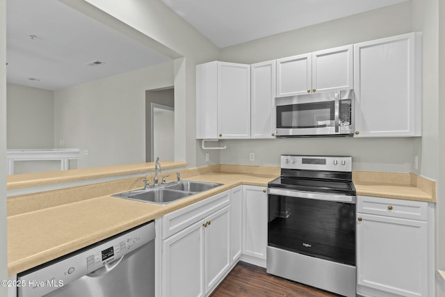 kitchen featuring appliances with stainless steel finishes, light countertops, white cabinets, and a sink