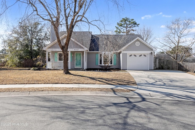 view of front of house featuring a garage, fence, and concrete driveway