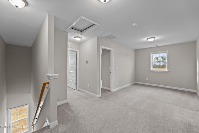 spare room featuring attic access, carpet, visible vents, and baseboards