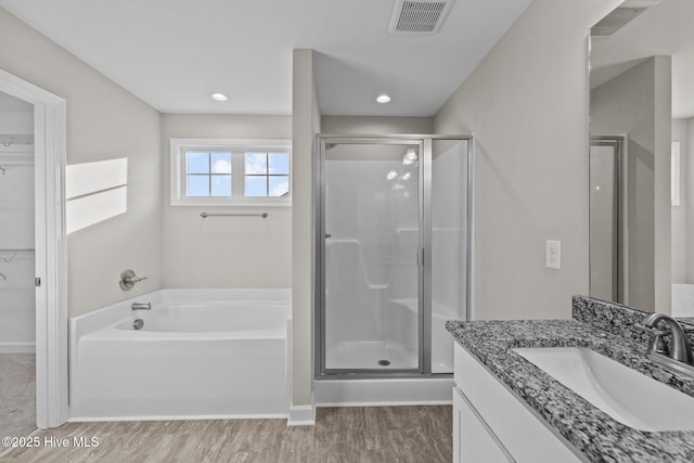 full bathroom with visible vents, a garden tub, a shower stall, and vanity