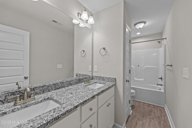 full bath featuring double vanity, visible vents, a sink, and wood finished floors