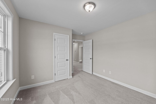 unfurnished bedroom featuring carpet flooring and baseboards