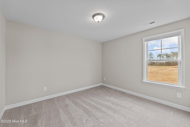 carpeted spare room featuring visible vents and baseboards