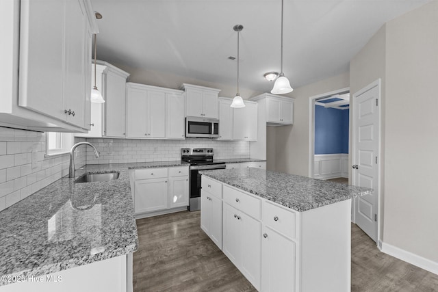 kitchen with stainless steel appliances, dark wood finished floors, white cabinetry, and a sink