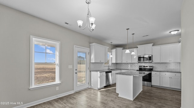 kitchen featuring appliances with stainless steel finishes, a sink, visible vents, and decorative backsplash