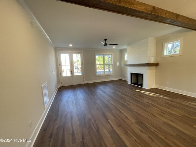 unfurnished living room with dark wood-style floors, a large fireplace, visible vents, and crown molding