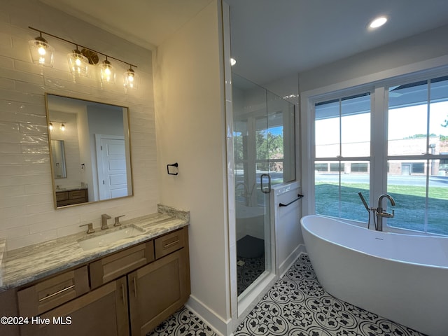 bathroom with tasteful backsplash, a stall shower, vanity, a freestanding tub, and tile patterned floors