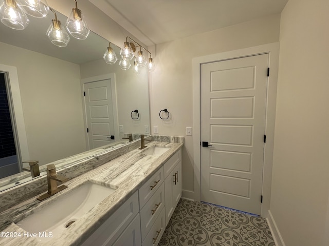 bathroom with double vanity, tile patterned flooring, baseboards, and a sink