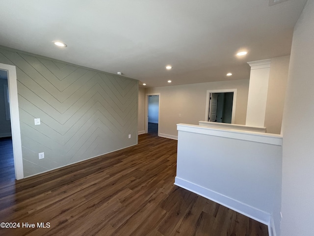 empty room with baseboards, dark wood finished floors, and recessed lighting