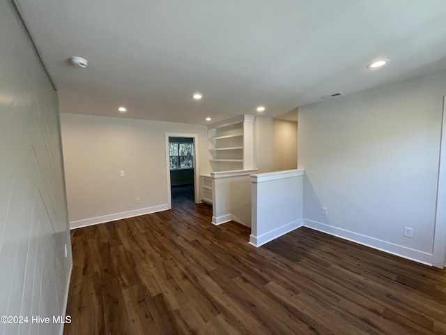 spare room featuring dark wood-style floors, baseboards, visible vents, and recessed lighting