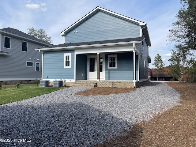 view of front facade featuring covered porch, driveway, and central AC