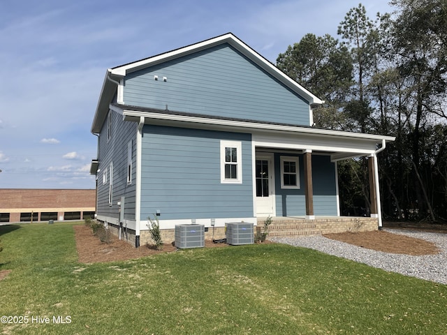 view of front of property with covered porch, a front lawn, and central AC