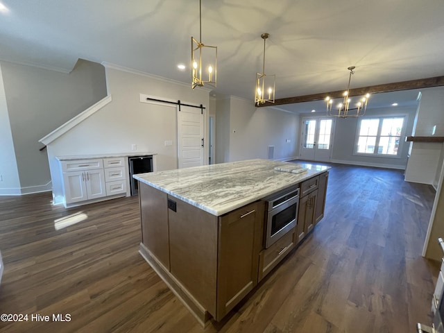 kitchen with a barn door, oven, dark wood-style flooring, open floor plan, and an inviting chandelier