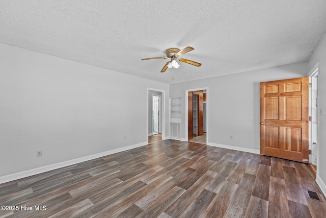 unfurnished room with a textured ceiling, dark wood-style flooring, a ceiling fan, visible vents, and baseboards