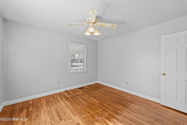 empty room featuring light wood-type flooring, visible vents, ceiling fan, and baseboards