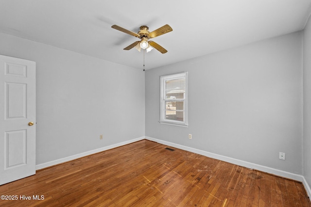 unfurnished room with hardwood / wood-style floors, visible vents, and baseboards