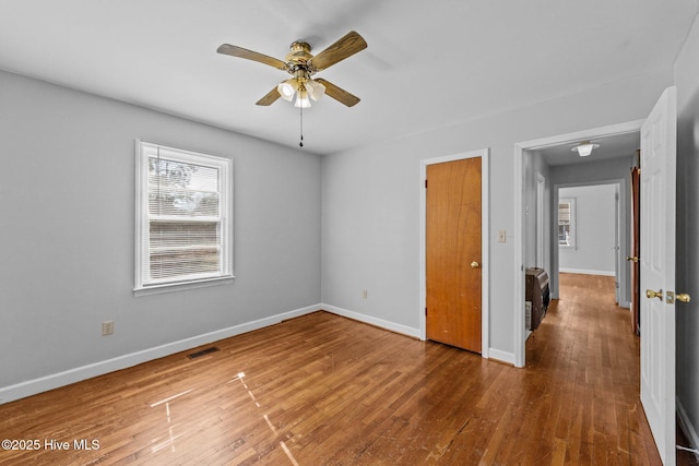 unfurnished bedroom with visible vents, baseboards, and wood finished floors