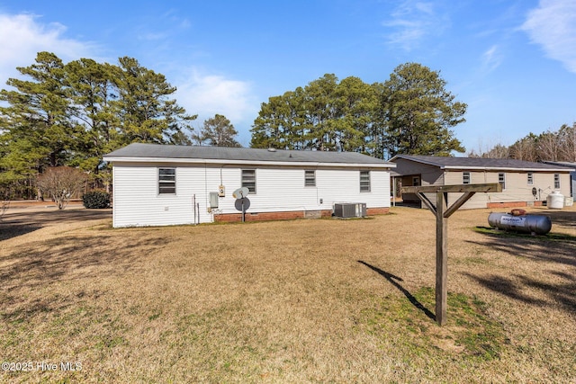 back of property featuring central AC and a lawn