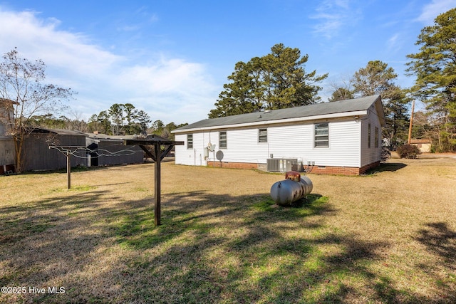 back of property with cooling unit and a yard