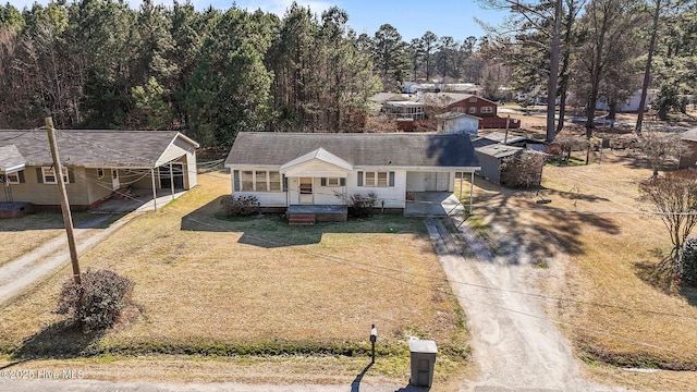 view of front of house featuring a porch, a front yard, and driveway