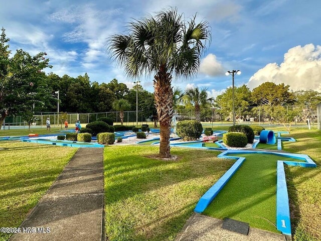 view of community with fence and a lawn