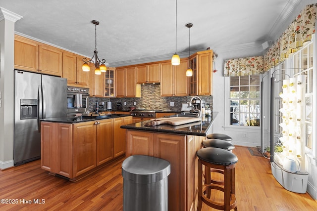 kitchen featuring crown molding, appliances with stainless steel finishes, tasteful backsplash, and a sink