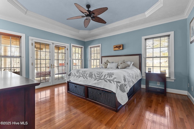 bedroom featuring baseboards, access to exterior, french doors, hardwood / wood-style floors, and a raised ceiling