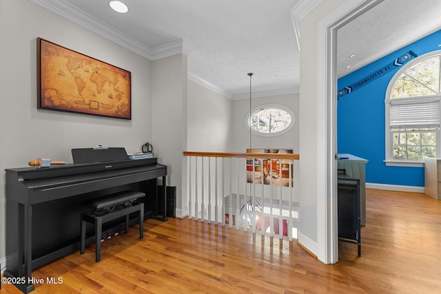 living area with ornamental molding, a chandelier, baseboards, and wood finished floors