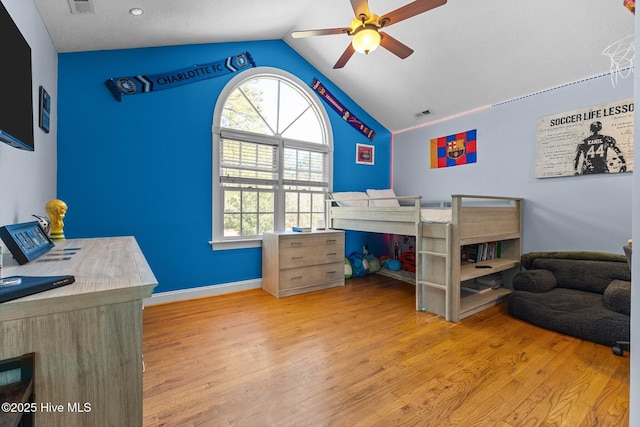 bedroom with vaulted ceiling, wood finished floors, visible vents, and a ceiling fan