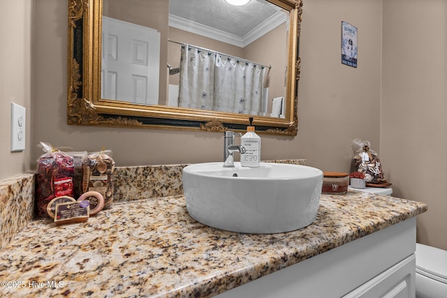 bathroom with a textured ceiling, curtained shower, toilet, vanity, and crown molding