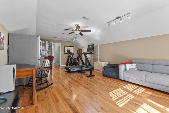 exercise room featuring lofted ceiling, visible vents, a ceiling fan, light wood finished floors, and track lighting