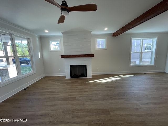 unfurnished living room with baseboards, ornamental molding, wood finished floors, a fireplace, and beam ceiling