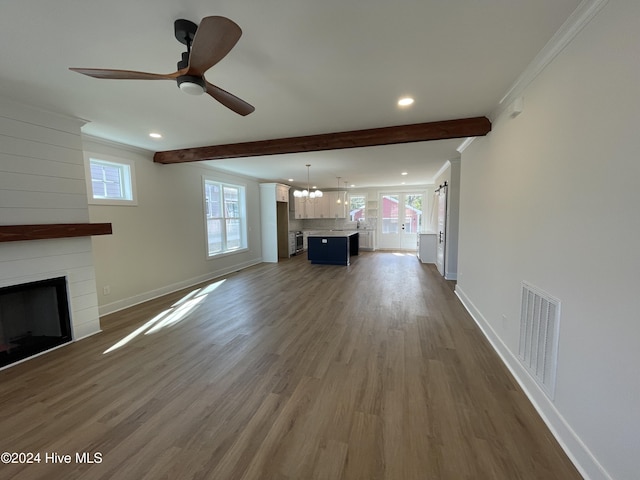 unfurnished living room featuring a large fireplace, dark wood-type flooring, visible vents, ornamental molding, and beamed ceiling